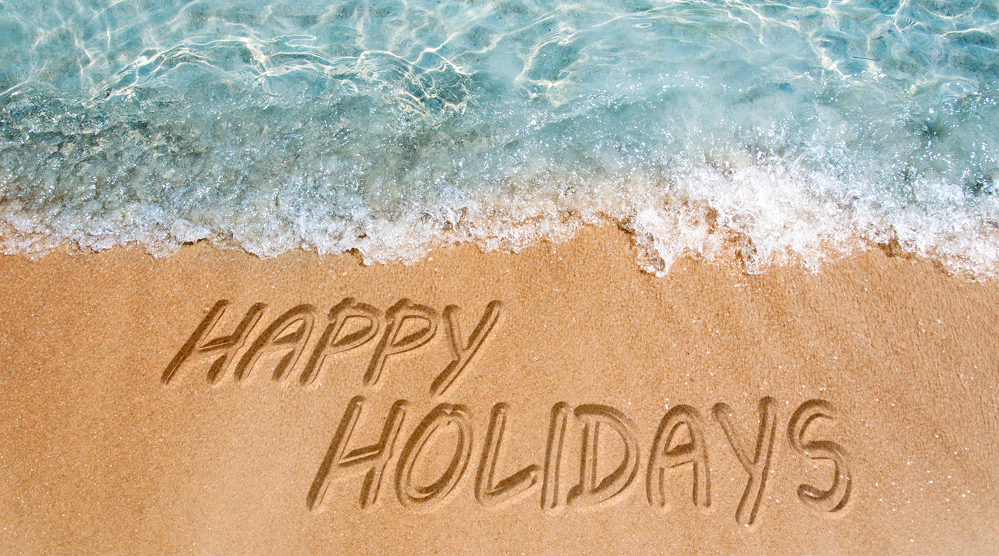 happy holidays written on beach