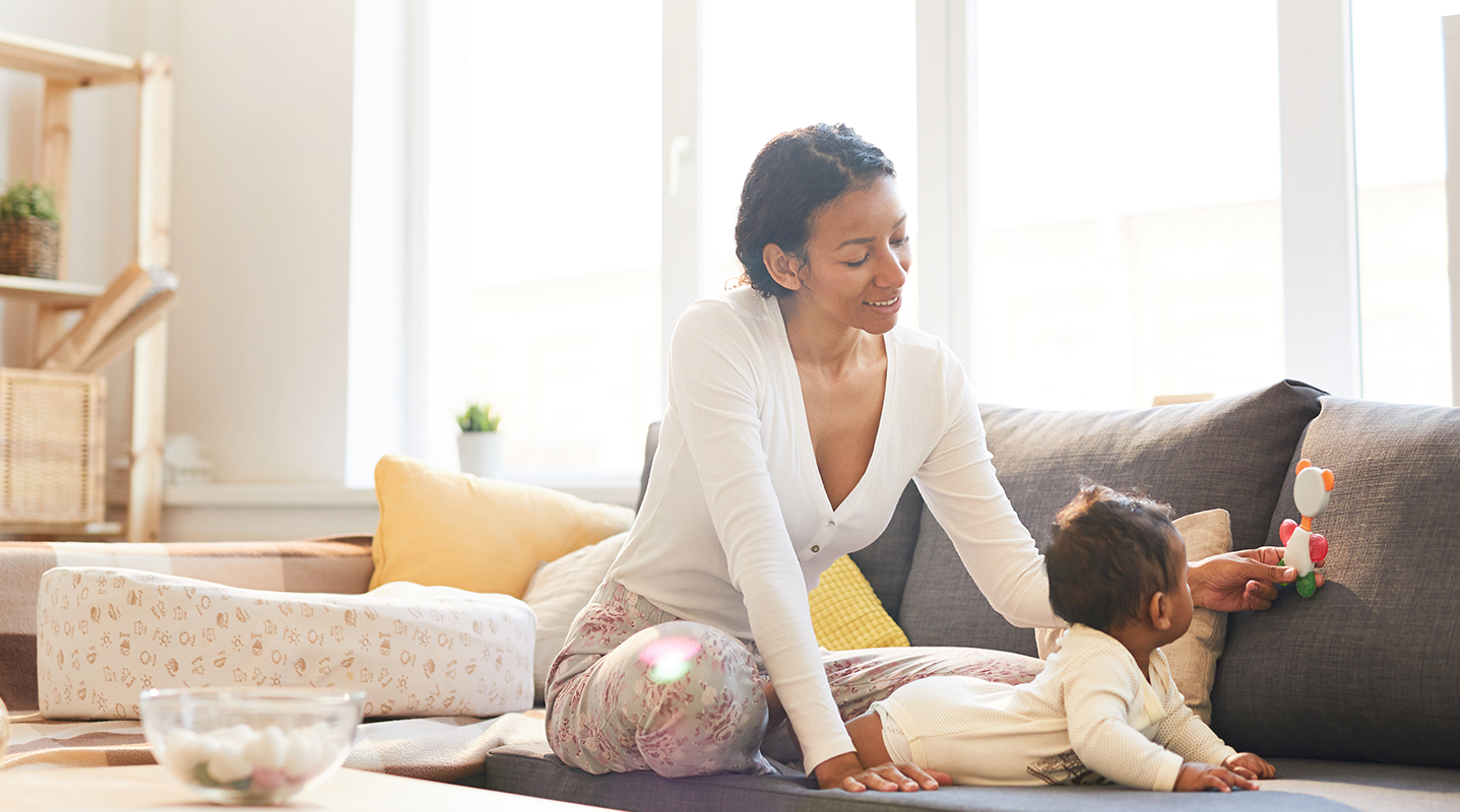 mom playing with baby on couch