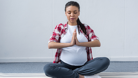 pregnant woman sitting in yoga pose