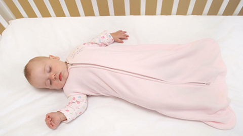 baby in sleep sack sleeping in crib