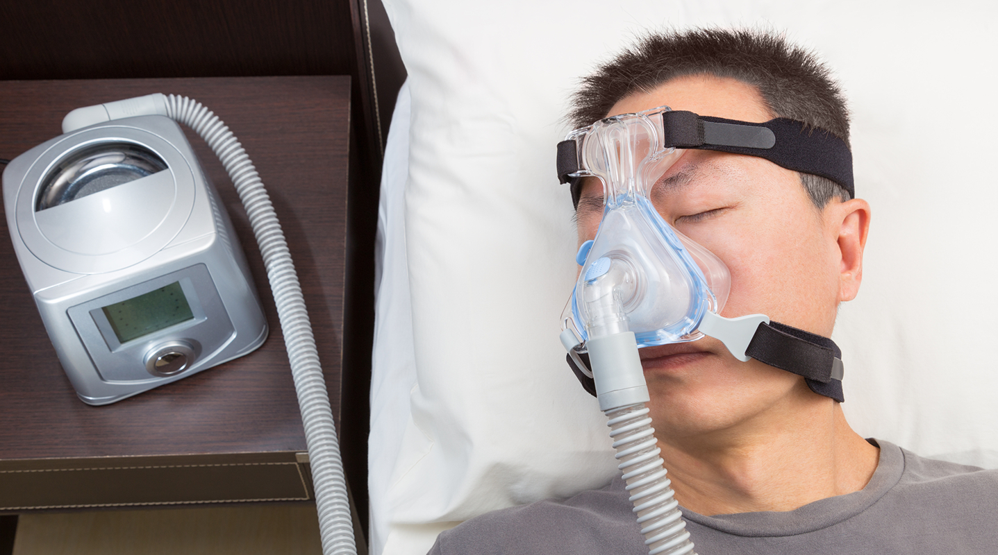 man sleeping with CPAP machine