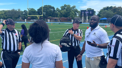 Dr. Geden Franck talking to referees on field at orange bowl classic