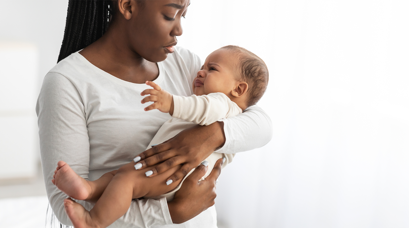 mom holding crying baby
