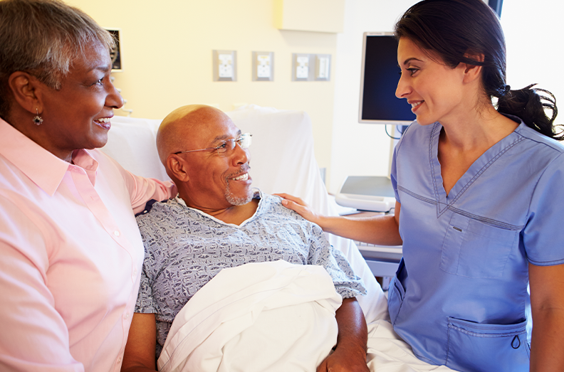 wife and husband smiling at nurse in hospital room