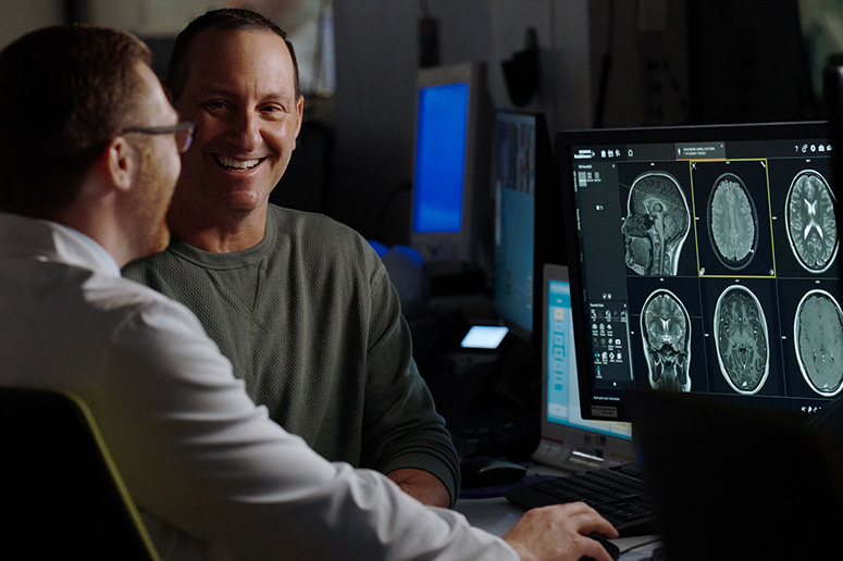 A patient and a doctor looking at brain scans.”