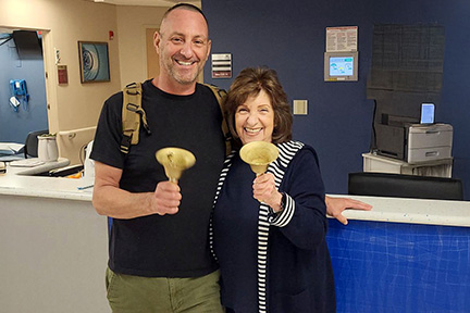 Scott smiles with a loved one as he rings the celebratory bell after completing chemo treatment, marking an important milestone in his care.